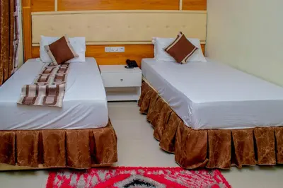 two beds sitting next to each other in a room at Jaden Hotel & Lounge - Arusha in Arusha