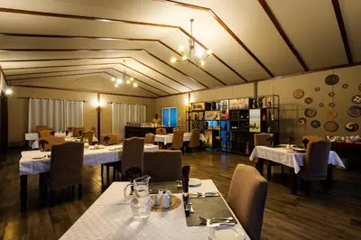 a restaurant with tables and chairs in a room at Serengeti Sametu Camp in Serengeti National Park