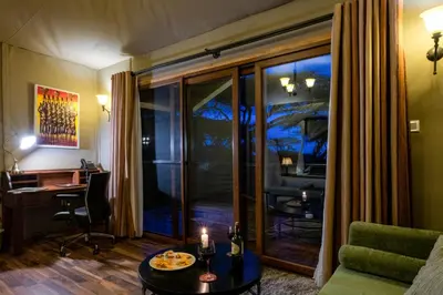 a living room with a table and a desk at Ngorongoro Lion's Paw in Ngorongoro