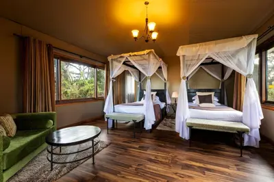 a bedroom with two beds and a couch at Ngorongoro Lion's Paw in Ngorongoro