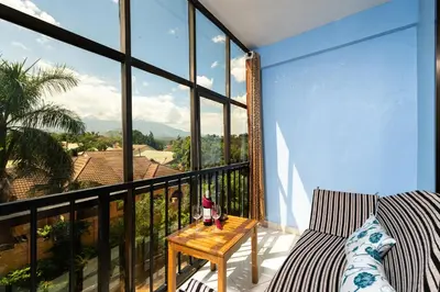 a balcony with a table and a view of the mountains at Mrimba Palm Hotel in Arusha