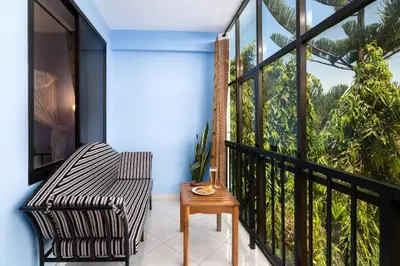 a balcony with a chair and a table at Mrimba Palm Hotel in Arusha