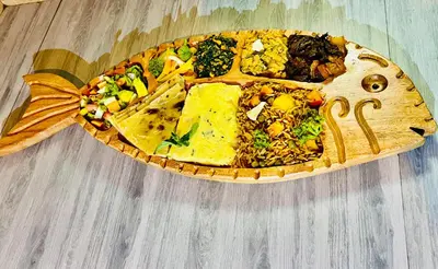 a plate of food with a fish on a table at Savannah House in Arusha