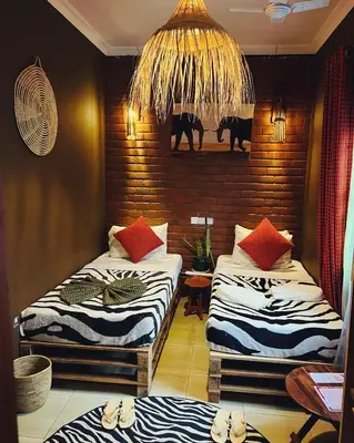 a room with two beds and a chandelier at Savannah House in Arusha