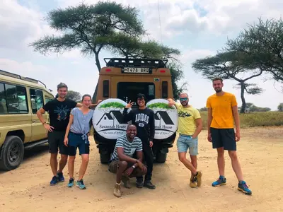 a group of people standing in front of a vehicle at Savannah House in Arusha