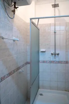 a shower with a glass door in a bathroom at Wakawaka Hostel Arusha in Arusha