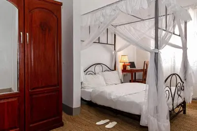 a bedroom with a bed with a canopy at Mama Wilsen House in Arusha