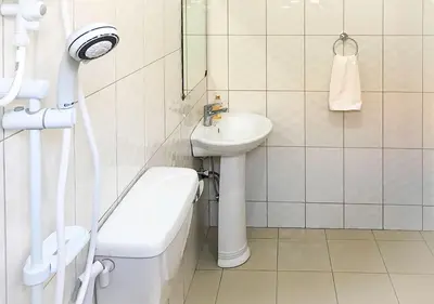 a white bathroom with a sink and a toilet at Mama Wilsen House in Arusha