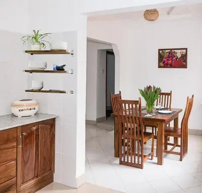 a kitchen and dining room with a table and chairs at Mama Wilsen House in Arusha