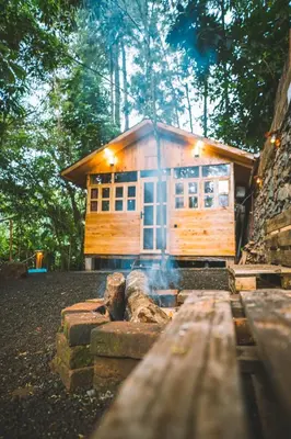 a log cabin with a fire in front of it at Banana Farm Eco Hostel in Arusha