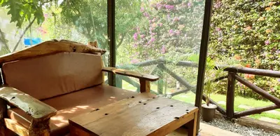 a wooden chair sitting in front of a large window at Fun Retreat Resort, Hotel and Ayurveda Spa in Arusha