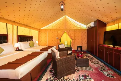 a room with two beds and a flat screen tv at Fun Retreat Resort, Hotel and Ayurveda Spa in Arusha