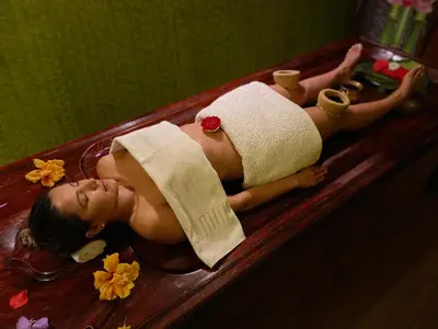 a woman laying in a bath tub with a towel at Fun Retreat Resort, Hotel and Ayurveda Spa in Arusha