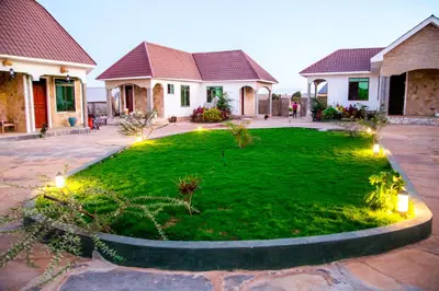 a yard with lights in front of a house at Asmorein Hotel in Babati