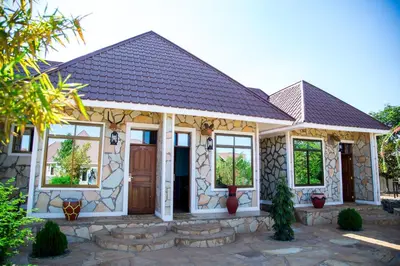 a house with a stone facade and a brown door at Asmorein Hotel in Babati
