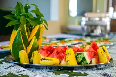 a tray of fruit on a table with a plate at Asmorein Hotel in Babati