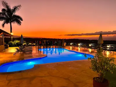 a resort pool with a sunset in the background at Pink Flamingo Boutique Hotel in Moshi