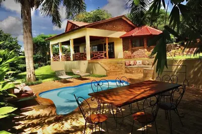 a house with a table in front of a pool at Pink Flamingo Boutique Hotel in Moshi