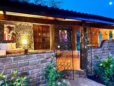 a front door of a house with a stone wall at Pink Flamingo Boutique Hotel in Moshi