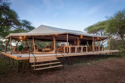 a tent with tables and chairs in a field at Baobab Tented Camp in Kwa Kuchinia