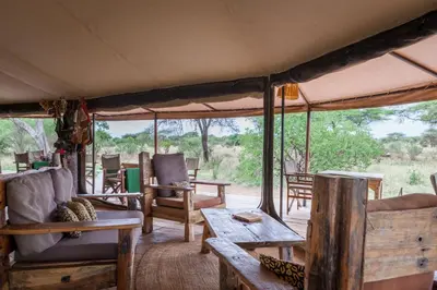 a living room of a safari tent with tables and chairs at Baobab Tented Camp in Kwa Kuchinia