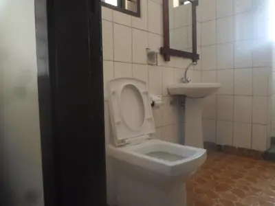 a bathroom with a white toilet and a sink at Climbers Home in Moshi