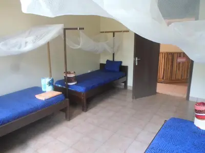 a room with two blue beds in a room at Climbers Home in Moshi