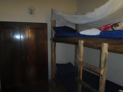 two bunk beds in a room with a door at Climbers Home in Moshi