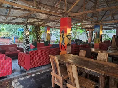 a restaurant with a wooden table and chairs at IBRAHIM Garden Hostel in Arusha