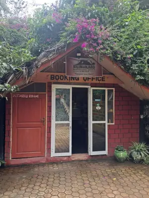 a red brick building with a door and a bookling office at IBRAHIM Garden Hostel in Arusha