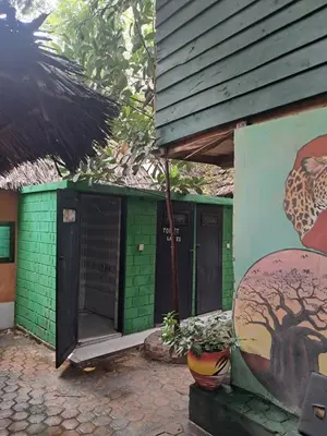 a green building with a painting of a tree at IBRAHIM Garden Hostel in Arusha