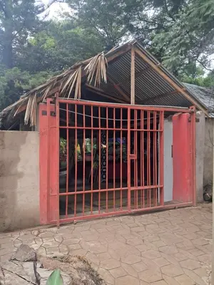a red gate in front of a building at IBRAHIM Garden Hostel in Arusha