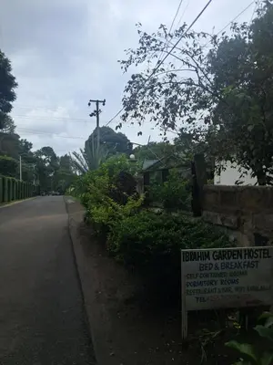 a sign on the side of a road at IBRAHIM Garden Hostel in Arusha