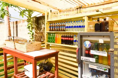 a drink cooler next to a table in front of a cooler at Utamaduni House B&B in Arusha