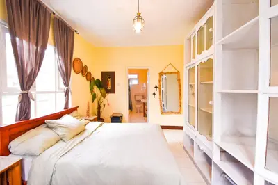 a bedroom with a white bed and a window at Utamaduni House B&B in Arusha
