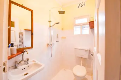 a bathroom with a sink and a toilet and a mirror at Utamaduni House B&B in Arusha
