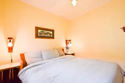 a bedroom with a white bed with two night stands at Utamaduni House B&B in Arusha