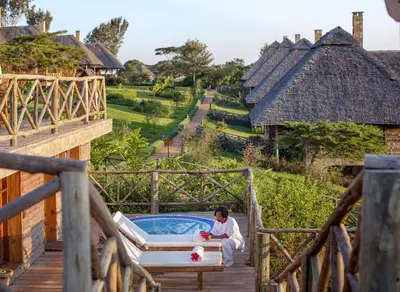 a woman sitting in a bath tub on a deck at Neptune Ngorongoro Luxury Lodge - All Inclusive in Ngorongoro
