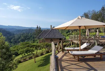 a deck with two lounge chairs and an umbrella at Neptune Ngorongoro Luxury Lodge - All Inclusive in Ngorongoro