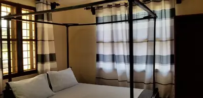 a bed in a room with a canopy bed with white pillows at Aivlys Lodge Kilimanjaro in Msaranga