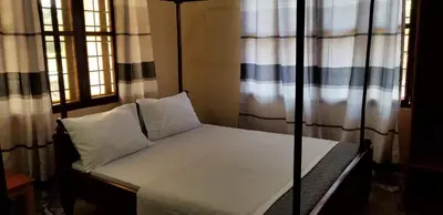 a small bed in a room with windows at Aivlys Lodge Kilimanjaro in Msaranga