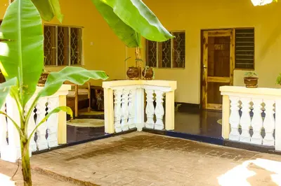 a living room with yellow walls and a white railing at Kiwavi Home in Moshi