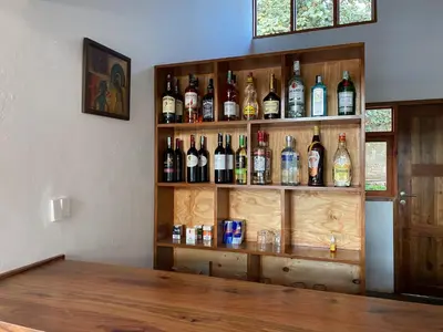 a shelf filled with lots of bottles of alcohol at Lilac Hideaway in Karatu