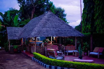 a gazebo with chairs and tables in a yard at The Better Inn in Moshi