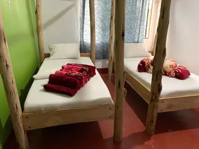 a room with two bunk beds with red blankets at The Better Inn in Moshi