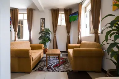 a living room with two chairs and a table at Two Mountains Lodge in Arusha