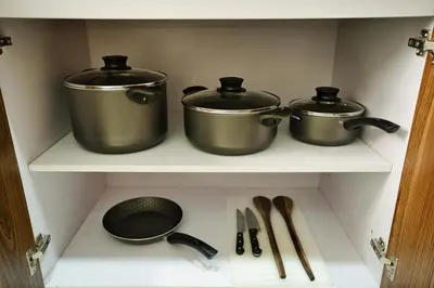 three pots and pans on a shelf in a kitchen at Kibo Palace Apartments in Arusha