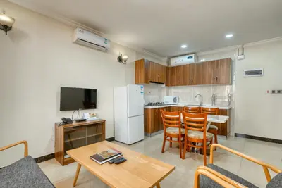 a living room with a table and a kitchen at Kibo Palace Apartments in Arusha