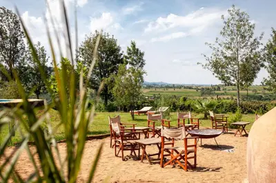 a group of chairs and tables in the sand at Karatu Tented Lodge in Karatu