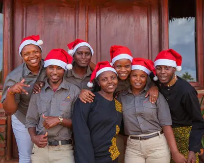 a group of people wearing christmas hats posing for a picture at Karatu Tented Lodge in Karatu